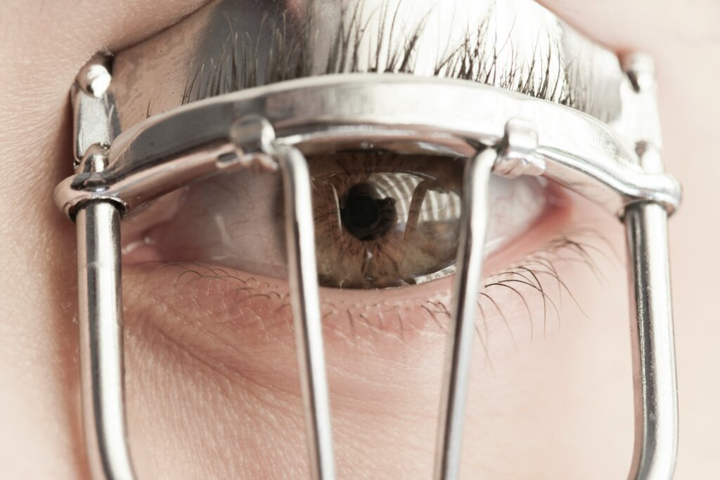 a woman curling her lashes