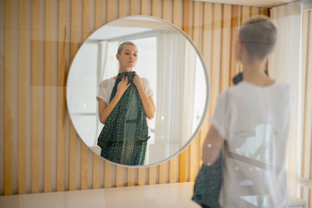 a woman posing in front of a mirror with a piece of clothing